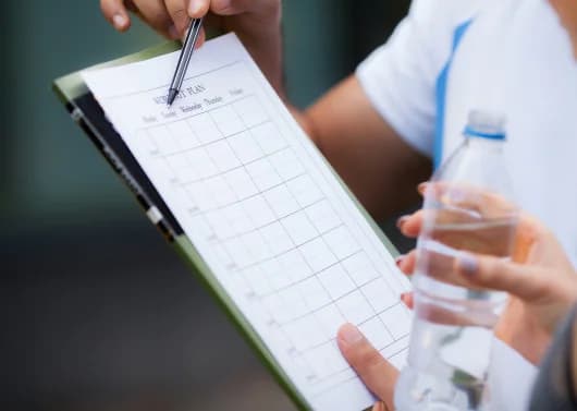 Client receiving personalized fat-loss guidance after hitting a weight loss plateau, trainer explaining progress metrics